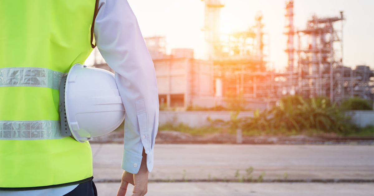 Someone standing holding a hard hat